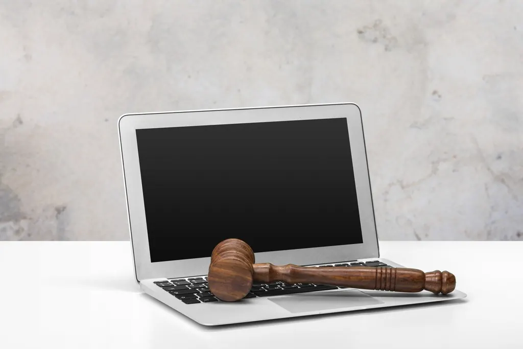 A judge's gavel resting on a laptop keyboard